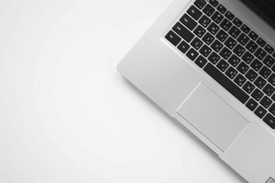 Minimalist laptop on white desk.